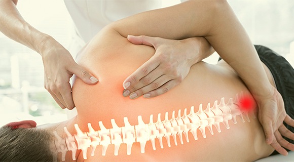 врач проводит мануальную процедуру спины пациента